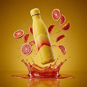 Gourde colorée avec éclaboussures de jus et agrumes en suspension