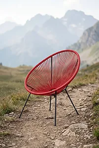 Fauteuil design rouge en extérieur dans un paysage montagneux