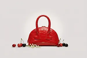 Sac à main rouge en packshot avec fruits décoratifs sur fond blanc