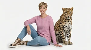 Femme assise en studio avec un léopard dans un décor épuré
