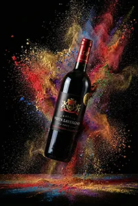 Bouteille de vin en lévitation avec explosion de poudres colorées