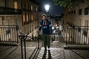Homme marchant de nuit en ville sous éclairage urbain